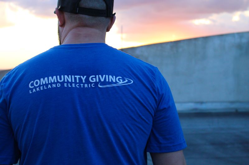 An employee wearing a Lakeland Electric Community Giving TShirt volunteering