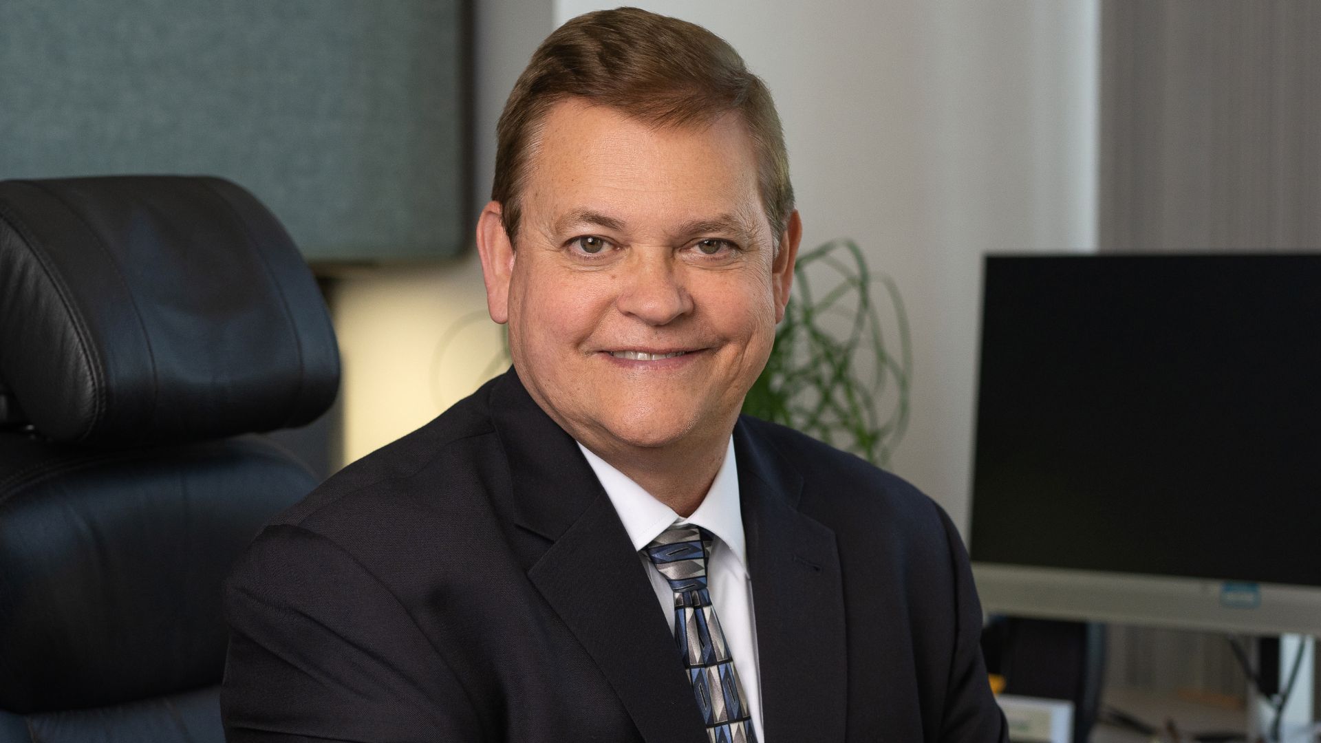 Image of Michael Beckham, General Manager of Lakeland Electric at his desk smiling.